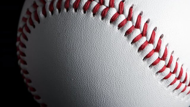 Close up of rotating baseball with black background.