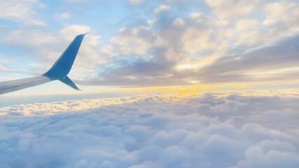Flying through the clouds overlooking the wing. Sunset sky from an airplane wing view of the horizon and sun lights
