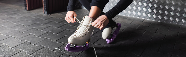 young woman tying laces on figure skating shoes, banner - obrazy, fototapety, plakaty