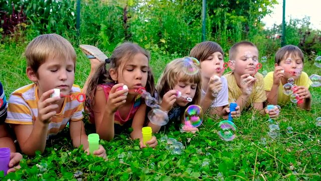 Children blow bubbles on the street. Selective focus.