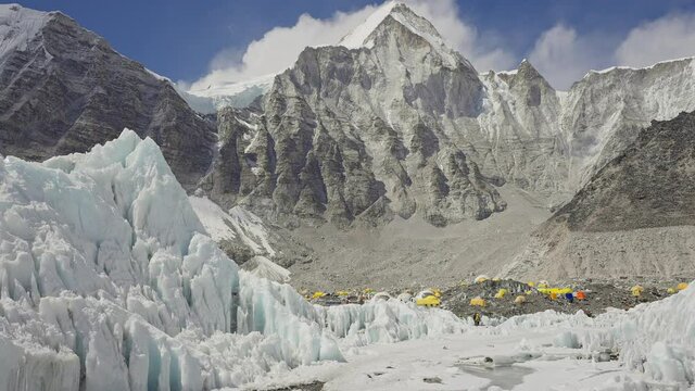 Panorama. Yellow tents at Everest Base Camp in snow mountains. Khumbu glacier