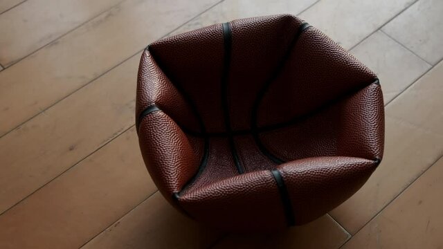 Close up deflated basketball on wooden floor.