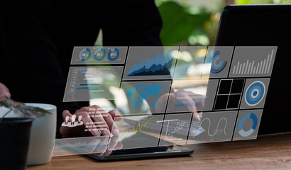 A female programmer analyzes and develops data on a future virtual interface screen using a laptop....