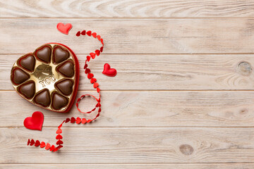 Delicious chocolate pralines in red box for Valentine's Day. Heart shaped box of chocolates top view with copy space