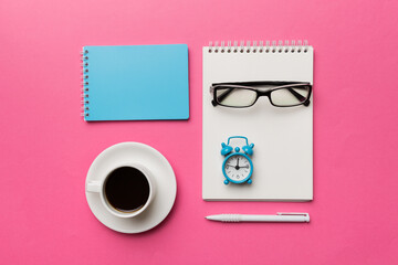 Modern office desk table with notebook and other supplies with cup of coffee. Blank notebook page for you design. Top view, flat lay