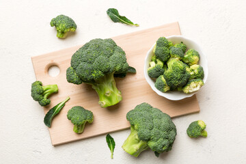 fresh green broccoli on wooden cutting board with knife. Broccoli cabbage leaves. light background. Flat lay