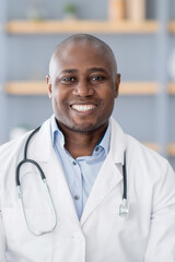 Health care remotely. Portrait of african american doctor in white coat with stethoscope in office interior, crop