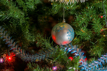 Green branches of a Christmas tree close-up, decorated with various beautiful festive toys and...