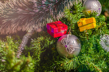 Bright Christmas decorations on a green festive tree: colored balls, garland, tinsel and...