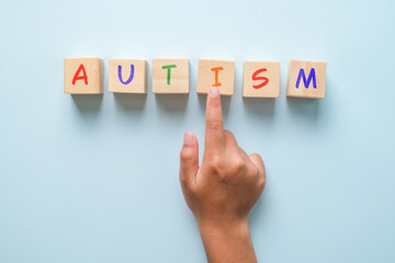 Children hand and autism on wooden squares blue background top view