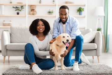 Black couple spending time at home with dog