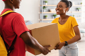 Happy African American Woman Receiving Box From Courier At Home