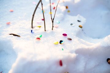 bright colored confetti on the snow during a holiday in nature and a fun New year's eve