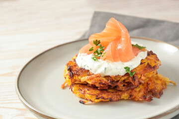 Appetizer pancakes from potato and red kuri squash with herb curd dip and smoked salmon for...