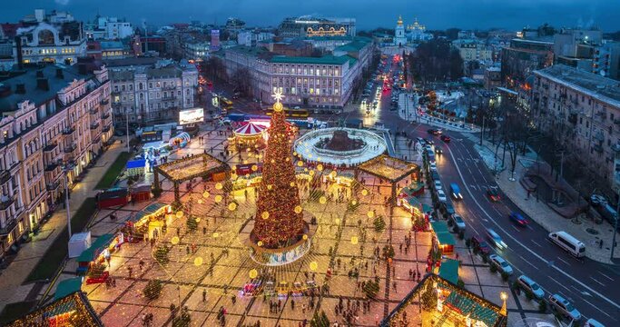 People enjoy the view of the New Year tree 2022 on Sophia Square, Kyiv, Ukraine. Time lapse