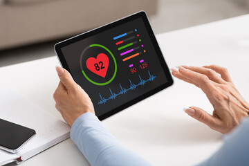 Female hands holding black pad with health app on screen