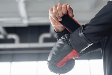 Cropped view of man wearing boxing glove in sports center