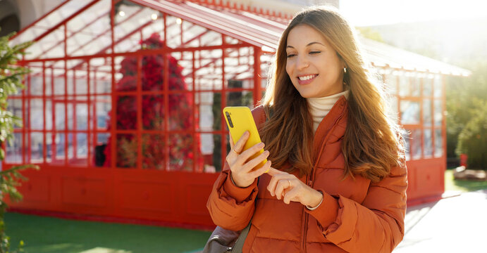 Panoramic Banner Of Beautiful Smiling Woman In Puffer Jacket Holding Smartphone On Christmas Time