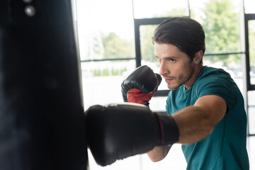 Sportsman boxing punching bag in sports center