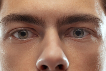 Blue eyes. Close-up upper face of young man. Man looking at camera. Handsome boy with well-kept...