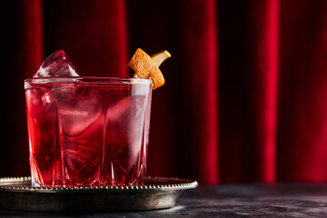 Glass of classic Negroni cocktail on marble table