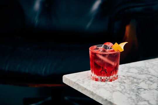 Glass of classic Negroni cocktail on marble table