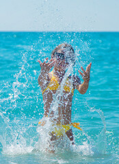 A child splashes water on the sea. Selective focus.