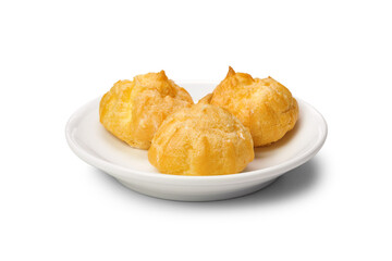 Hollow profiteroles filled with sweet cream on white plate isolated on white background, close up.
