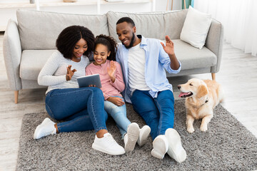 Black family having videocall using laptop waving hands