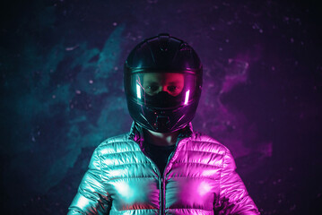 A portrait of motorbiker in the helmet in the neon lights.