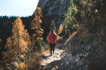 Young woman standing on a top of the mountains with the beautiful view. Autumn Dolomites in the Italy.