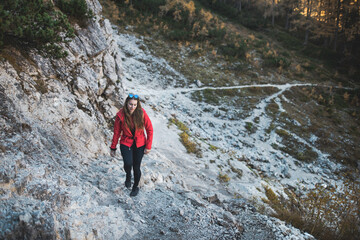 Obraz premium Young woman standing on a top of the mountains with the beautiful view. Autumn Dolomites in the Italy.