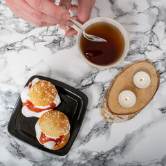 Overhead shot of a plate with traditional shrove buns and a teacup on a granite countertop