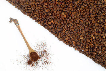 Coffee beans in a wooden scoop isolated on a white background. Roasted coffee beans isolated. A wooden scoop with coffee.