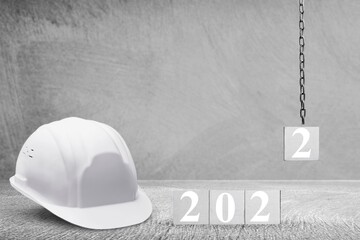 Happy New Year 2022 Construction and Industry. Helmet and a numbered cube on the desk