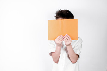Little boy reading a book and covering her face on white background.