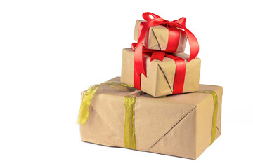 Gift box wrapped in Kraft paper with red and golden ribbon on white background. Holiday or Christmas gift boxes background.