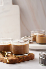 Italian chocolate and coffee mousse dessert semifreddo - half-frozen ice cream with whipped cream and cocoa powder in small glasses