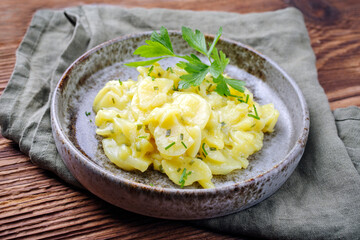 Traditioneller deutscher Kartoffelsalat mit Zwiebel und Schnittlauch serviert als close-up in einer...