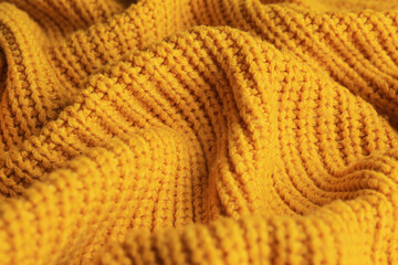 Beautiful orange knitted fabric as background, closeup