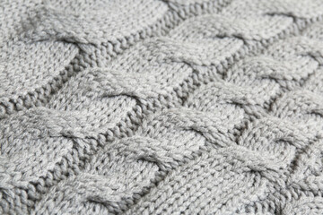 Grey knitted fabric with beautiful pattern as background, closeup