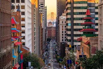 Poster Famous view of California Street near China Town and the Financial District, with Chinese pagoda towers and the Bay Bridge at sunset in San Francisco © SvetlanaSF