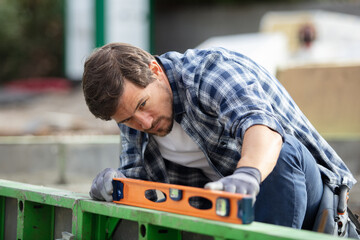 man using a spirit level to check a surface