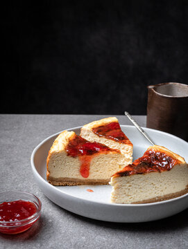 Cut cheesecake with jam placed on table