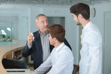 apprentices listening to manager at hotel reception