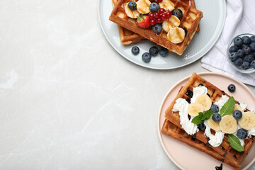 Delicious Belgian waffles served on light marble table, flat lay. Space for text