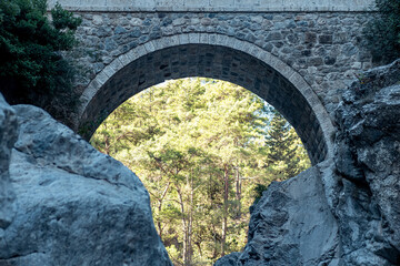 arch of ancient Roman bridge over a mountain river in the Kesme Bogazi canyon, Turkey