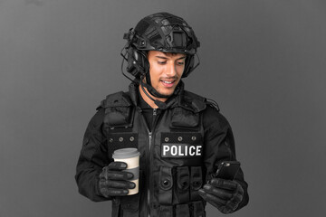 SWAT caucasian man isolated on grey background holding coffee to take away and a mobile