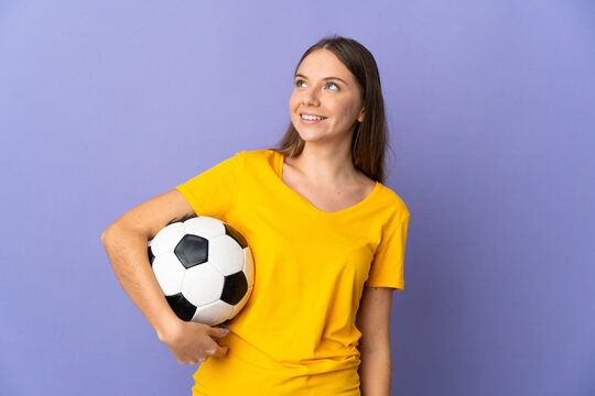 Young Lithuanian football player woman isolated on purple background thinking an idea while looking up
