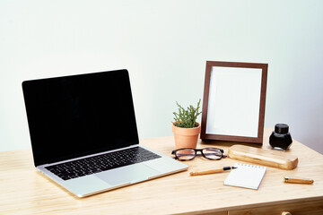Photo frame with laptop on table on background